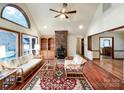 Bright living room features vaulted ceiling, brick fireplace, wood floors, and ample natural light at 965 Hunting Ave, Lincolnton, NC 28092