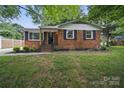 Inviting brick home with lush green lawn and well-maintained front yard at 9818 Starwood Dr, Charlotte, NC 28215