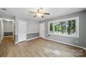 Bright living room featuring wood floors and large windows, and a ceiling fan at 9818 Starwood Dr, Charlotte, NC 28215