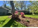 Well-manicured yard with mature tree and colorful flowerbeds at 1035 15Th Nw Ave, Hickory, NC 28601
