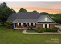 Charming brick home featuring a welcoming front porch, manicured lawn, and a well-maintained landscape at 105 Gold Run Ct, Kings Mountain, NC 28086