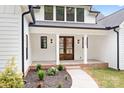Inviting front entrance with beautiful wood double doors and landscaped garden beds at 106 Arbor Dr, Waxhaw, NC 28173