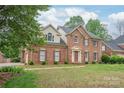 Charming two-story brick home featuring a well-manicured lawn and a classic architectural design at 114 Sardis Plantation Dr, Matthews, NC 28105