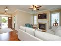 Cozy living room with a fireplace, ceiling fan, hardwood floors, and neutral walls at 11607 Meetinghouse Dr, Cornelius, NC 28031