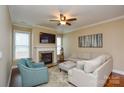 Comfortable living room featuring a fireplace, plush seating, hardwood floors, and large windows at 11607 Meetinghouse Dr, Cornelius, NC 28031