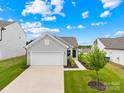 Exterior of home with a two-car garage, beautiful landscaping, and a well manicured lawn at 130 Slalom St, Statesville, NC 28677