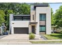 Contemporary home design featuring a two-car garage, stone accents, and professionally landscaped front yard at 1620 S Tryon St, Charlotte, NC 28203