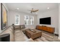 Modern living room with large sectional couch, stylish ottoman, and big-screen television at 235 S Bruns Ave, Charlotte, NC 28208