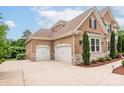 Spacious three car garage with a paved driveway and exterior brickwork to match the house at 3009 Ocaso Ct, Matthews, NC 28104