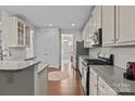 Bright kitchen featuring granite countertops, stainless steel appliances, and hardwood floors at 308 Planters Way, Mount Holly, NC 28120