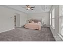 Spacious bedroom with a ceiling fan, walk-in closet and natural light from the windows at 308 Planters Way, Mount Holly, NC 28120