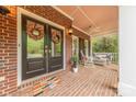Charming front porch with brick floor, decorative wreaths, and comfortable seating area at 3318 Providence Hills Dr, Matthews, NC 28105