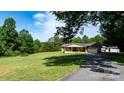 Well-maintained brick home with a charming covered porch, complemented by green lawns and mature trees at 3423 S Hwy 127 Hwy, Hickory, NC 28602