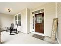 Charming covered front porch with rocking chairs, a dark wood front door, and a welcoming mat at 3807 Blazeprince Dr, Charlotte, NC 28215