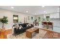 Open-concept living room with hardwood floors, comfortable seating, and lots of natural light at 3900 Colebrook Rd, Charlotte, NC 28215