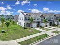 Lovely townhomes with lush green lawn and mature trees, creating a welcoming and picturesque neighborhood setting at 4003 Rothwood Ln, Harrisburg, NC 28075