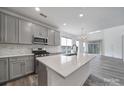 Modern kitchen with an island, stainless steel appliances, and sleek countertops perfect for cooking and entertaining at 4003 Rothwood Ln, Harrisburg, NC 28075