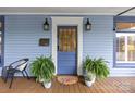 Stylish blue front door with glass panels flanked by sconces and potted ferns at 413 E Worthington Ave, Charlotte, NC 28203