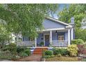 Charming blue two-story home featuring a welcoming front porch, landscaped yard, and a brick walkway at 413 E Worthington Ave, Charlotte, NC 28203