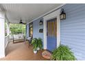 Comfortable front porch with seating, plants, ceiling fans, and a stylish front door at 413 E Worthington Ave, Charlotte, NC 28203