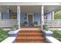 Inviting front porch with brick steps, plants, and cozy seating, perfect for relaxing outdoors at 413 E Worthington Ave, Charlotte, NC 28203
