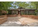 Welcoming facade showcases a brick-accented driveway, mature trees, and inviting front entrance at 449 Windward Dr, Davidson, NC 28036