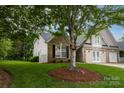 Well-maintained home with a brick and vinyl siding, mature tree, and green lawn at 4637 Willow Glen Rd, Harrisburg, NC 28075