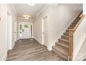 Welcoming foyer featuring wood-look flooring, a staircase, and views of the front door at 5408 Unionville Brief Rd, Unionville, NC 28110
