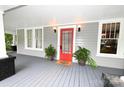 Inviting front porch featuring a bright red door, gray flooring, and decorative potted plants at 616 N Deal Ave, Newton, NC 28658
