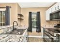 Stylish kitchen showcasing granite countertops, stainless steel appliances, and dark accents at 6401 Windsor Gate Ln, Charlotte, NC 28215