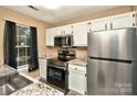 Well-lit kitchen featuring stainless steel appliances, granite countertops, and white cabinetry at 6401 Windsor Gate Ln, Charlotte, NC 28215