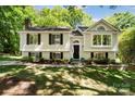 Charming two-story home with light yellow siding, black shutters, and manicured front yard at 7018 Rollingridge Dr, Charlotte, NC 28211