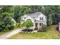 Aerial view of home featuring lush landscaping, a long driveway, and mature trees creating a private and serene setting at 8256 Chatham Oaks Dr, Concord, NC 28027
