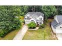 Aerial view of a well-maintained home with lush landscaping, a long driveway, and mature trees creating a private setting at 8256 Chatham Oaks Dr, Concord, NC 28027