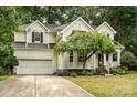 Well-manicured lawn leads up to the home's front exterior, showcasing its architectural features and mature landscaping at 8256 Chatham Oaks Dr, Concord, NC 28027