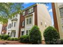 A view of a two story townhome with brick accents and manicured landscaping at 9651 Bailey Rd, Cornelius, NC 28031
