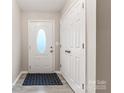 Inviting foyer with a white front door, patterned mat, and closet at 9651 Bailey Rd, Cornelius, NC 28031