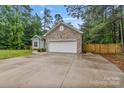 Exterior of the home features a two car garage, a manicured lawn and mature trees at 105 Stumpy Creek Rd, Mooresville, NC 28117