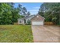 Charming single-story home featuring a brick facade, lush lawn, and attached two car garage at 105 Stumpy Creek Rd, Mooresville, NC 28117