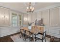 Charming dining room featuring wainscoting, a chandelier, and a rustic wood table at 117 Walking Horse Trl, Davidson, NC 28036