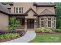 Elegant front entrance with stone accents, a decorative door, and manicured landscaping at 117 Walking Horse Trl, Davidson, NC 28036