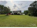 Expansive front lawn with lush greenery surrounding a charming single-Gathering home at 13219 Asbury Chapel Rd, Huntersville, NC 28078