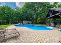 Backyard pool with stone waterfall, cabana, and lounge chairs, ideal for relaxation and enjoyment at 1522 12Th Fairway Nw Dr, Concord, NC 28027