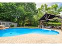 Backyard pool with waterfall feature, cabana, and lounging area provides an inviting outdoor space at 1522 12Th Fairway Nw Dr, Concord, NC 28027