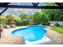 A backyard pool with a waterfall feature and a cabana offers a relaxing outdoor retreat at 1522 12Th Fairway Nw Dr, Concord, NC 28027