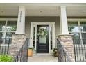 Inviting entryway featuring a decorative wreath, stone accents, and stylish railings at 15515 Laverack Ln, Davidson, NC 28036