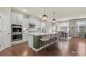 Bright kitchen features a large center island with seating and pendant lighting at 15515 Laverack Ln, Davidson, NC 28036