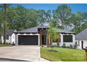 Attractive one-story house featuring a black garage door, landscaped yard, and a welcoming entrance with modern design elements at 1626 Burtonwood Cir, Charlotte, NC 28212