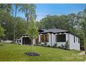 A bright, white brick home with an expansive lawn, modern garage, dark trim and an elegantly minimalist front entry at 1626 Burtonwood Cir, Charlotte, NC 28212