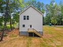 Rear view of new home featuring white siding, professionally installed windows and a wooden staircase at 1723 Rhyneland Cir, Gastonia, NC 28054